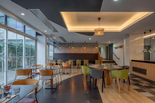 a restaurant with tables and chairs and windows at DoubleTree by Hilton Paris Bougival in Bougival