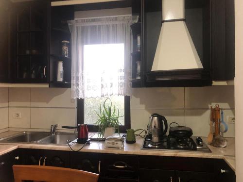 eine Küche mit einem Waschbecken und einem Fenster in der Unterkunft Tafilaj Apartments in Durrës