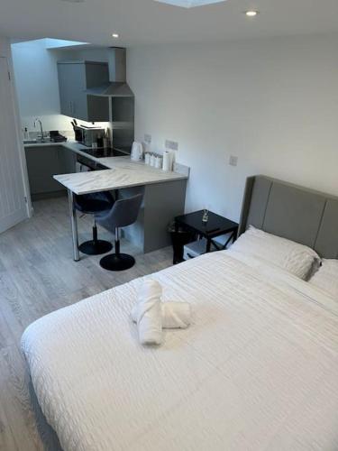 a bedroom with a bed and a desk and a kitchen at Whitsun Studio - Brand New listing! in Bristol