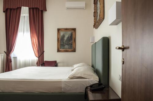a bedroom with a bed and a window at Hotel San Guido in Milan