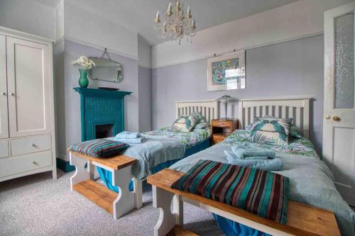1 dormitorio con 2 camas, mesa y chimenea en Large character home, hot tub, beach 5 min walk en Gorleston-on-Sea