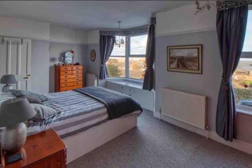 a bedroom with a bed and a window at Large family home, sea view, hot tub, beach 5 min walk, dog friendly in Gorleston-on-Sea