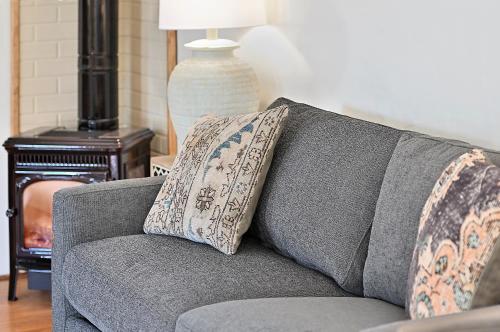 a gray couch with two pillows on it in a living room at Dos Hermanas 4, 5, 6 & 8 Sleeps 12 Downtown in Santa Fe