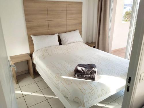 - une chambre avec un lit doté d'un grand couvre-lit blanc dans l'établissement Appartement le Grau du roi, au Grau-du-Roi