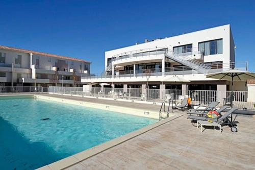 une piscine devant un immeuble dans l'établissement Appartement le Grau du roi, au Grau-du-Roi