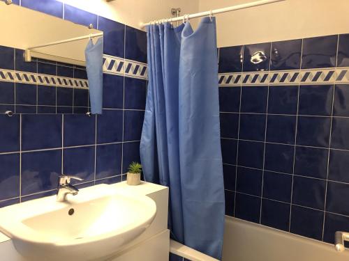 een blauwe betegelde badkamer met een wastafel en een douche bij Ocealine, Proche plages, Vue Salines, U71 in Carnac