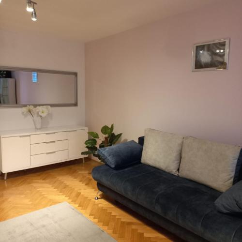 un soggiorno con divano nero e cassettiera di Apartment Blue Moon a Lubiana