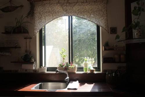 eine Küchenspüle in einer Küche mit Fenster in der Unterkunft A house with a view in Tel Kazir