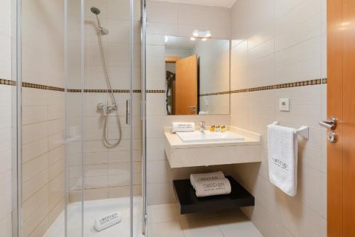 uma casa de banho com um chuveiro, um lavatório e um espelho. em OBSIDIAN Olivino em Adeje