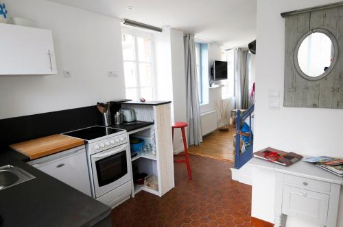 een keuken met een wastafel en een fornuis top oven bij Maison cosy vue mer à 50m de la plage in Étretat