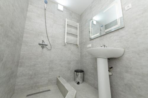 een witte badkamer met een wastafel en een douche bij Anna's Guest House in Gori