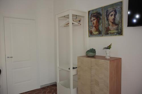 エルコラーノにあるCasa Graziosaの白いクローゼットと木製のキャビネットが備わる客室です。