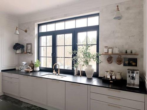 a kitchen with a sink and a large window at Villa am Wald in Meckenheim