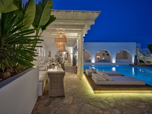 a resort with a swimming pool at night at Stelia Mare Boutique Hotel in Naousa