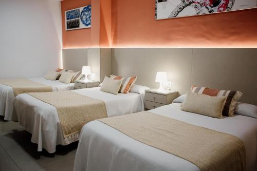 een groep van drie bedden in een kamer bij Pensión Mastil 16 in Málaga