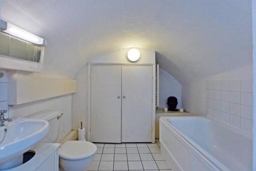 y baño con bañera, aseo y lavamanos. en 2 Bedroom Home Central London Victoria London en Londres