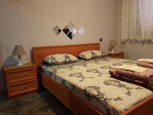 um quarto com uma cama com duas mesas de cabeceira e dois candeeiros em Къща за гости Жорж em Bankya