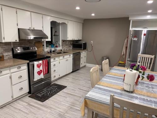 a kitchen with white cabinets and a table with a dining room at House on Farm in Rosemonte