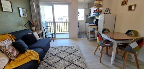 un salon avec un canapé bleu et une table dans l'établissement Ref 098 - Appartement moderne et rénove sur Port Crouesty pour quatre, à Arzon