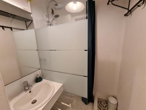 une salle de bain blanche avec un lavabo et une douche dans l'établissement Ref 098 - Appartement moderne et rénove sur Port Crouesty pour quatre, à Arzon