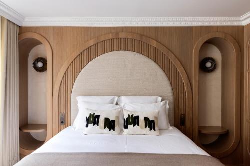 a bedroom with a large white bed with a wooden headboard at HIGHSTAY - Luxury Serviced Apartments - Centre Pompidou in Paris