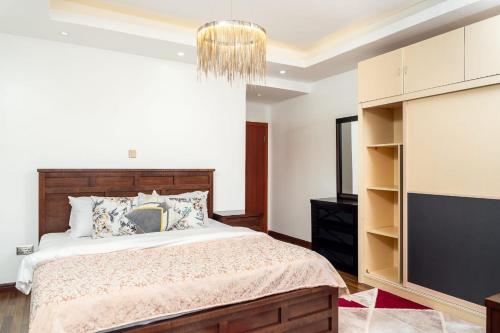 a bedroom with a large bed and a chandelier at Sylver Harbour 2 Bedroom Apartment in Nairobi