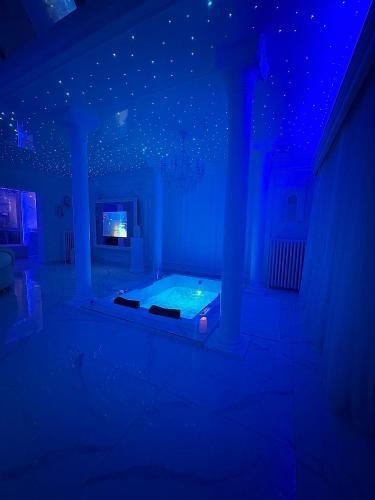 une chambre bleue avec un lit et un plafond avec des étoiles dans l'établissement La suite santorini, à Villemomble