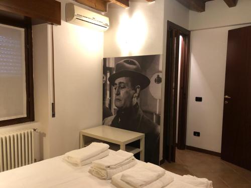 una camera da letto con un dipinto di un uomo con un cappello di La casetta della felicità, comodità tra Milano e Bergamo a Capriate San Gervasio