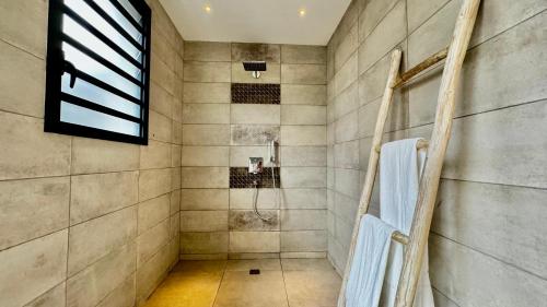 a bathroom with a shower with a shower curtain at Villa familiale avec piscine in Tamarin