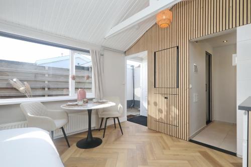 une chambre avec une table, des chaises et une fenêtre dans l'établissement Huisje bij Zee (gratis parkeren), à Noordwijk aan Zee