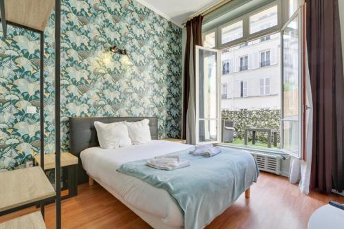1 dormitorio con 1 cama con papel pintado azul y blanco en 253 Suite Martinez - Superb apartment in Paris, en París