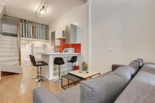 sala de estar con sofá gris y cocina en 253 Suite Martinez - Superb apartment in Paris en París