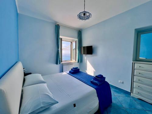 a bedroom with a bed with blue sheets and a window at Bella Tropea Suite in Tropea
