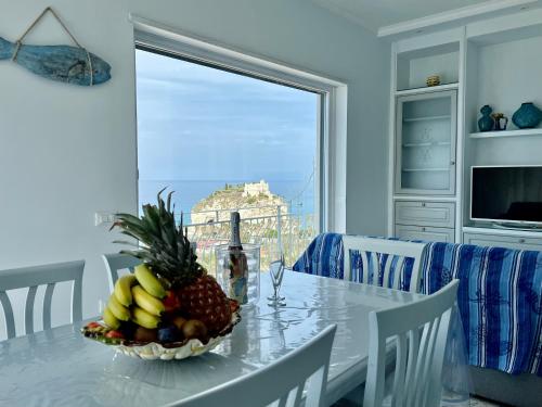 a dining room table with a bowl of fruit on it at Bella Tropea Suite in Tropea
