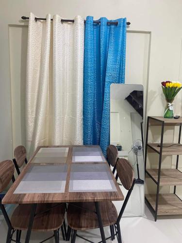 a dining room with a table and blue curtains at Pagadian Staycation in Camella 1 in Pagadian
