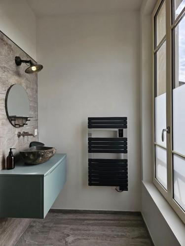 une salle de bain avec un lavabo et un miroir dans l'établissement Métamorphose Champenoise, à Épernay