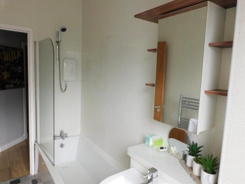 a bathroom with a sink and a shower and a mirror at City Centre 2 bedroom apt, close to M8 & Tourist Attractions in Glasgow