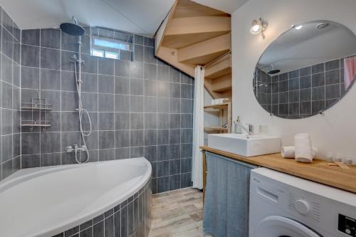 une salle de bain avec une baignoire, un lavabo et un miroir dans l'établissement Estrela by Yumē, à Toulouse