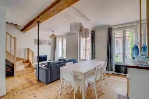 une cuisine et un salon avec une table et des chaises blanches dans l'établissement Estrela by Yumē, à Toulouse