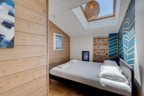 a bedroom with a bed in a room with wooden walls at Estrela by Yumē in Toulouse