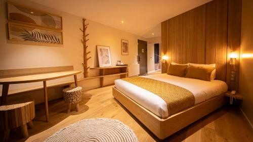 1 dormitorio con cama y escritorio. en Hôtel Ecolodgee en Chasseneuil-du-Poitou