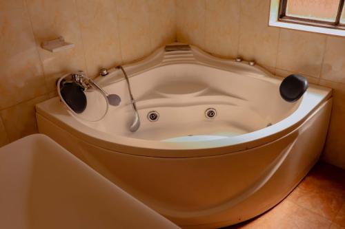 a bath tub in a corner of a bathroom at Kigali Homes Villa in Kigali