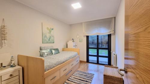 um quarto com uma cama e uma grande janela em Apartamento Rompeolas em Llanes