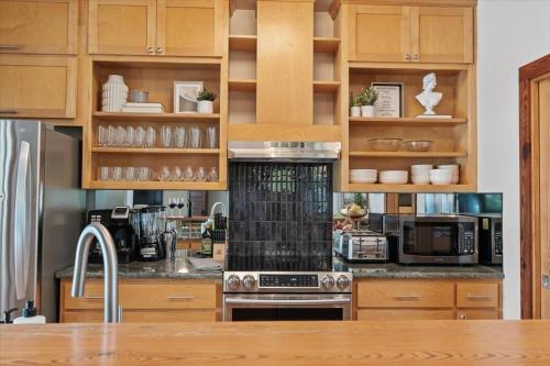 a kitchen with wooden cabinets and a stove top oven at Urban Cowboy Villas - Heart of 704 in Austin