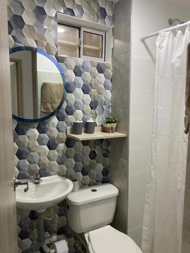 a bathroom with a toilet and a sink and a mirror at Apto Boho in Cartagena de Indias