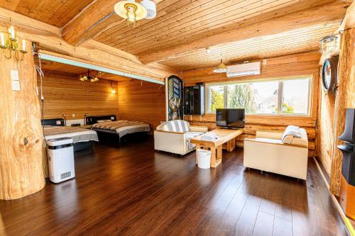 una sala de estar con paneles de madera y una habitación con muebles. en ゲストハウス風の丘 en Tōbetsu