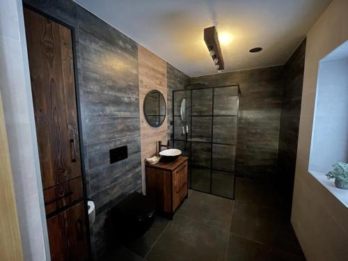 a bathroom with a sink and a shower with a mirror at Tajemniczy Ogród 