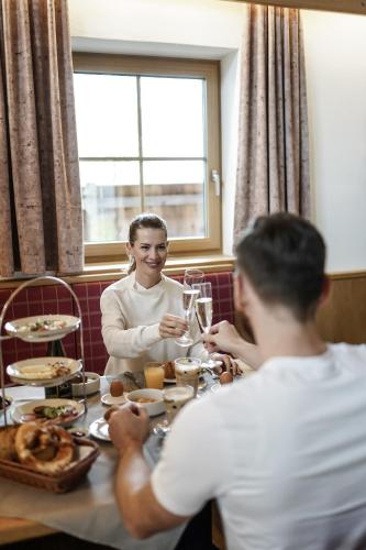 Un hombre y una mujer sentados en una mesa en Wellness-Appartements Berchtesgadener Land, en Ainring