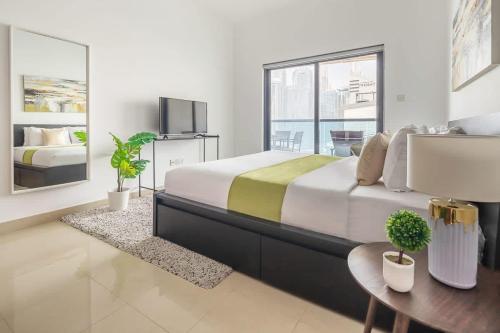 a bedroom with a large bed and a tv at Frank Porter - Time Place Tower in Dubai