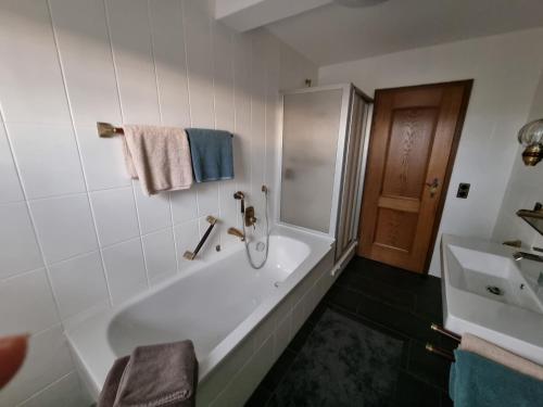 ein weißes Badezimmer mit einer Badewanne und einem Waschbecken in der Unterkunft Ferienwohnung 120 in Schloß Holte-Stukenbrock